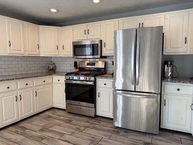 1 Bruce Street Avon, MA 02322 - Photo 3 of 23 a kitchen with cabinets stainless steel appliances and wooden floor