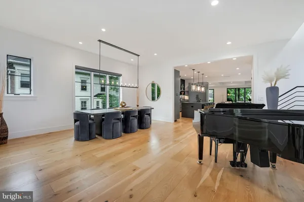 a living room with furniture a large window and wooden floor