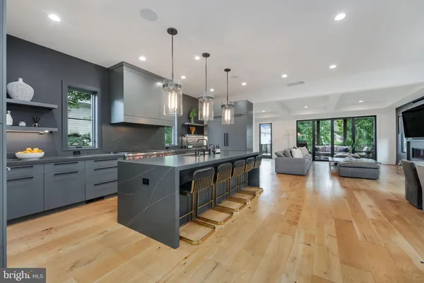 a large kitchen with stainless steel appliances kitchen island granite countertop a large counter top a sink a stove and a wooden floors