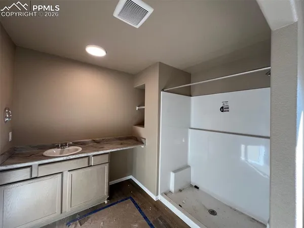 a bathroom with a granite countertop sink toilet and shower