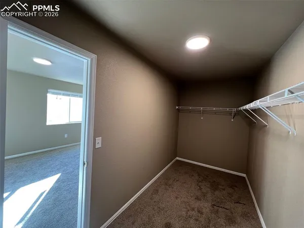 an empty room with fan and windows