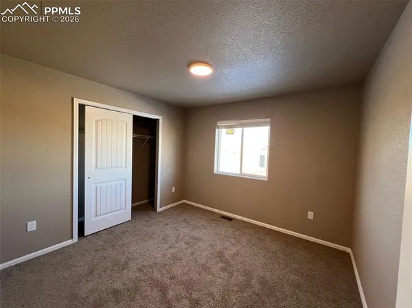 an empty room with closet and a bathroom