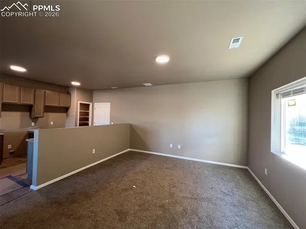 a view of a big room with kitchen and windows