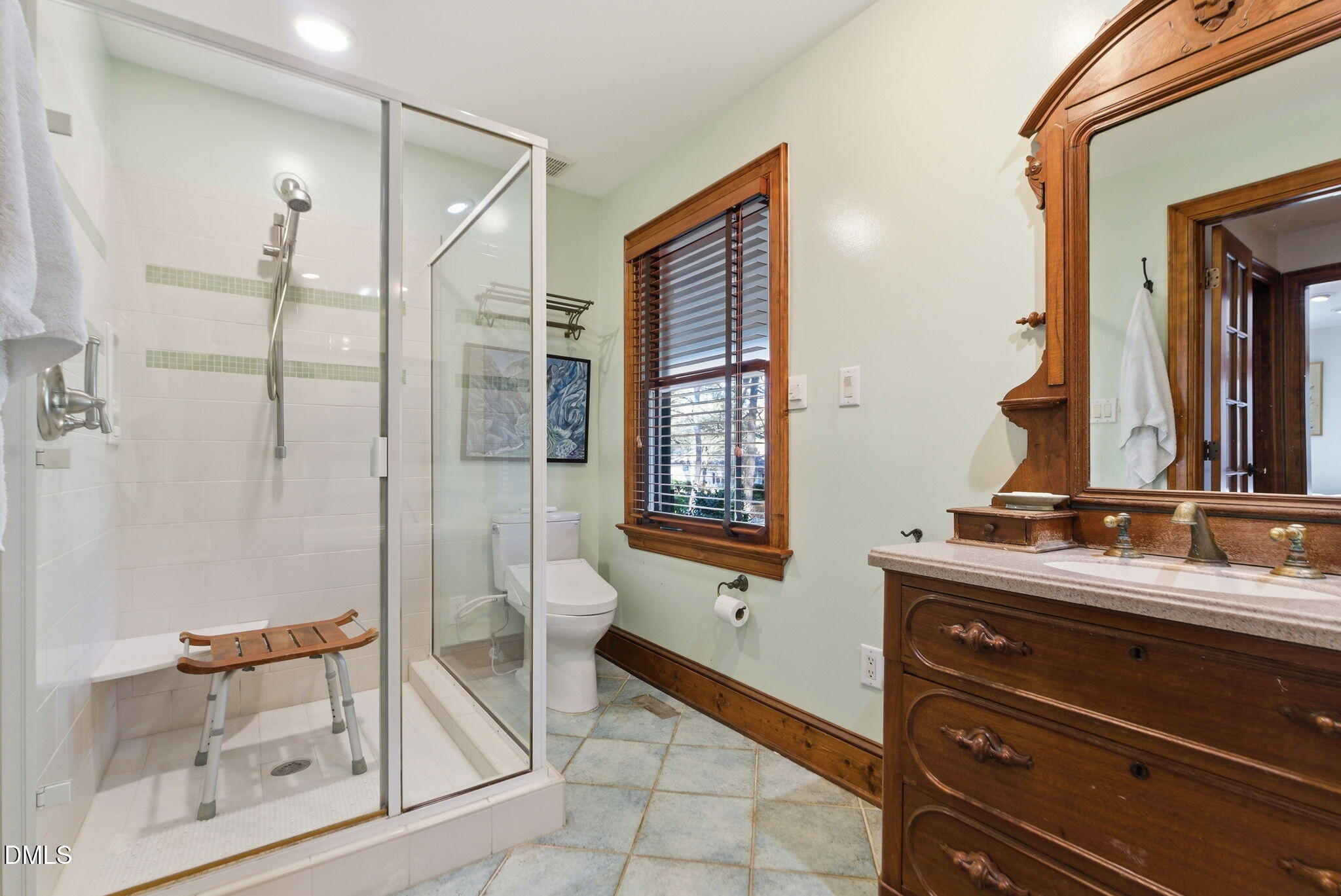 1513 Dellwood Drive Raleigh, NC 27607 - Photo 29 of 76 a bathroom with a double vanity sink a mirror and a shower