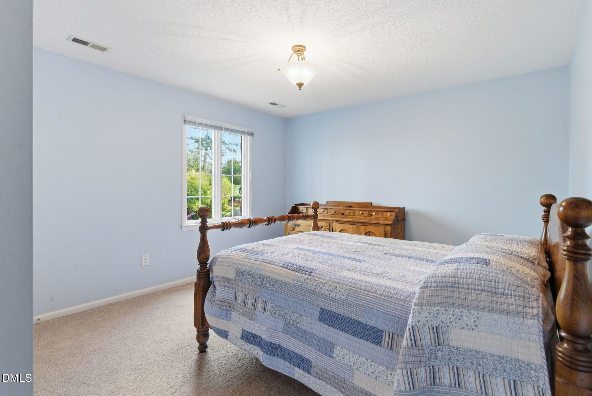 1513 Dellwood Drive Raleigh, NC 27607 - Photo 45 of 76 a bedroom with a bed and a chandelier