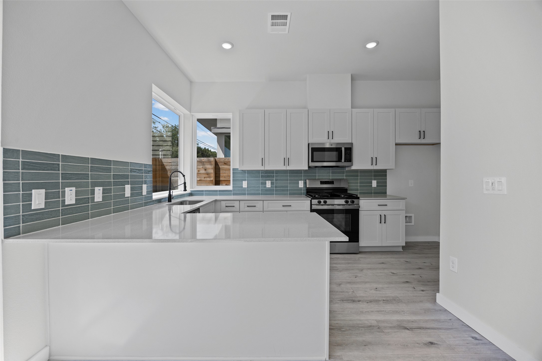 A well-appointed kitchen boasts sleek white cabinetry, stainless steel appliances, and ample counter space for culinary pursuits.