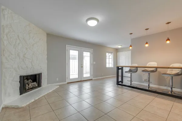 a view of an empty room with a fireplace and a window