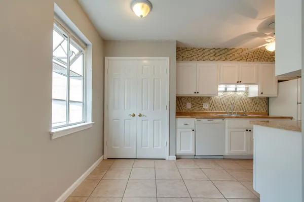 a room with two sinks a lamp and a window