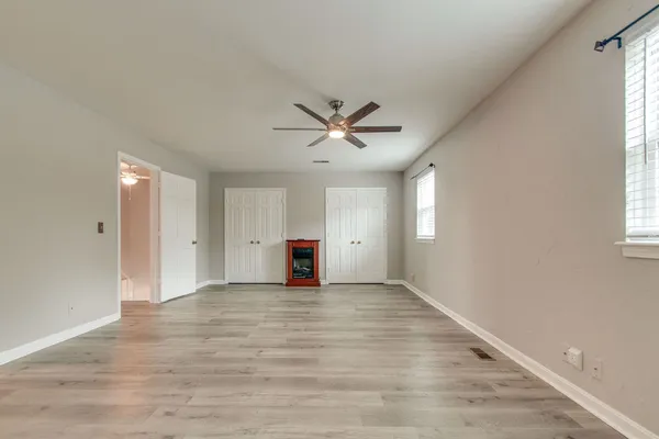 a view of a big room with wooden floor and windows