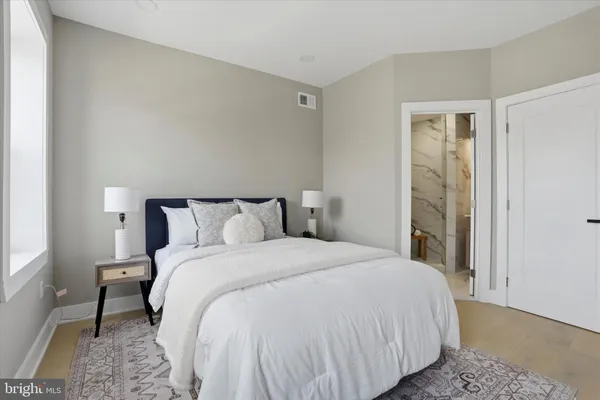 a bedroom with a large window and a balcony
