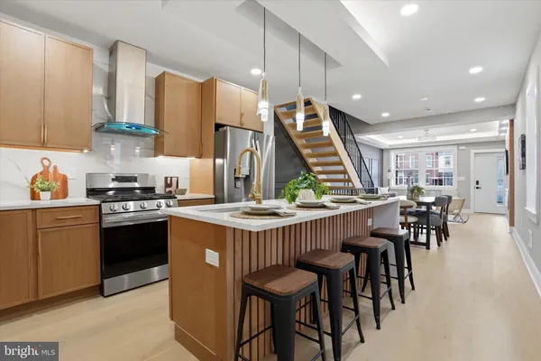 a kitchen with stainless steel appliances granite countertop a table chairs sink and cabinets