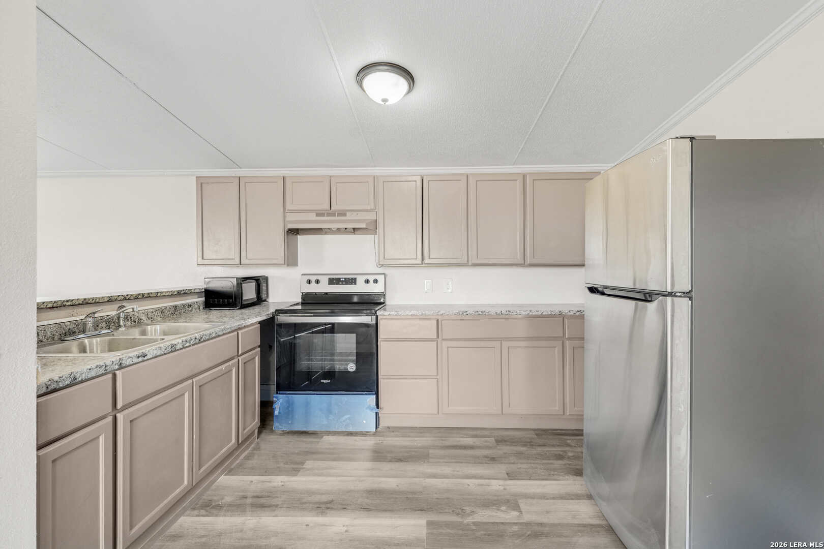 2811 County Road 467 Devine, TX 78016 - Photo 10 of 28 a kitchen with white cabinets and white appliances