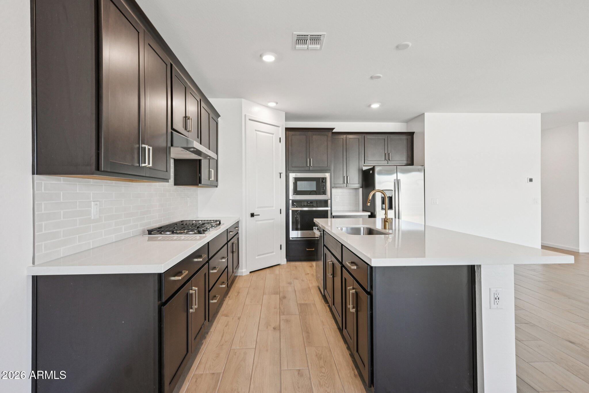 16206 West Red Bird Road Surprise, AZ 85387 - Photo 12 of 35 a kitchen with stainless steel appliances granite countertop a sink stove and refrigerator