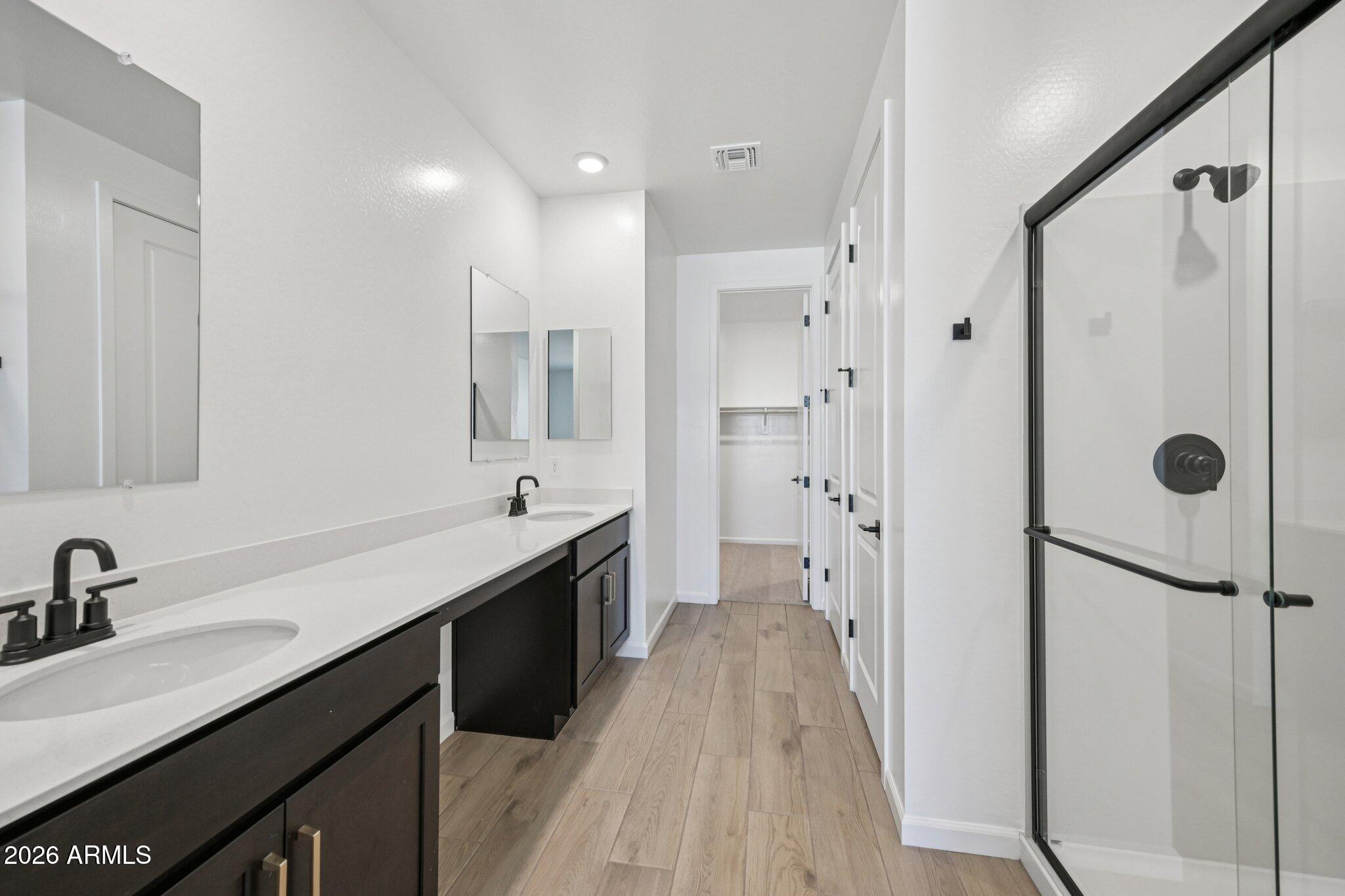 16206 West Red Bird Road Surprise, AZ 85387 - Photo 16 of 35 a spacious bathroom with a double vanity sink a mirror a shower and a bathtub