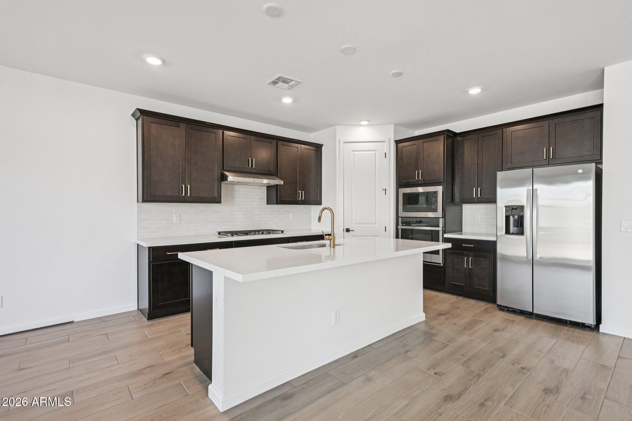 16206 West Red Bird Road Surprise, AZ 85387 - Photo 5 of 35 a kitchen with stainless steel appliances a refrigerator stove microwave and sink
