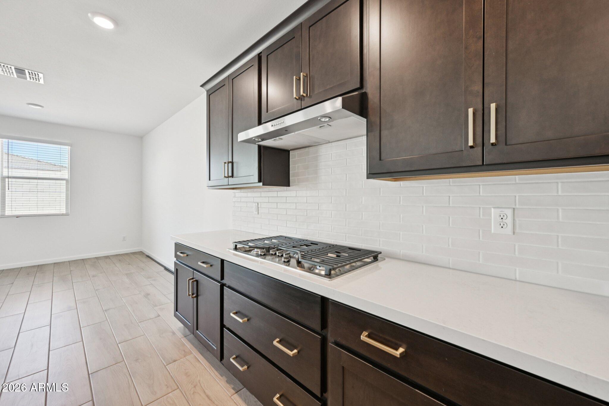 16206 West Red Bird Road Surprise, AZ 85387 - Photo 7 of 35 a kitchen with granite countertop a stove and a microwave