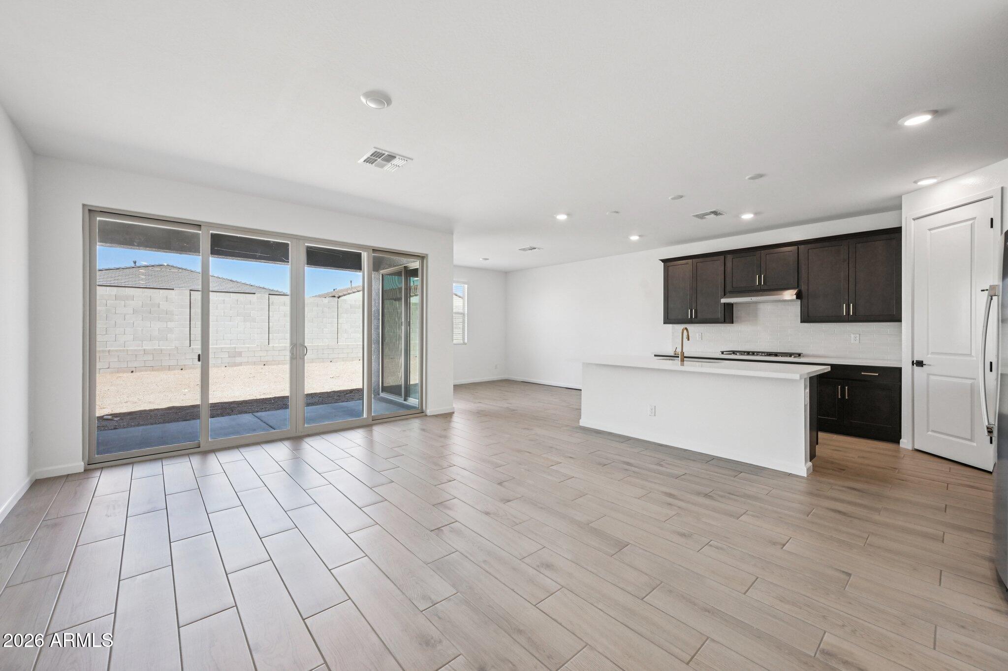 16206 West Red Bird Road Surprise, AZ 85387 - Photo 8 of 35 a big room with wooden floor and windows