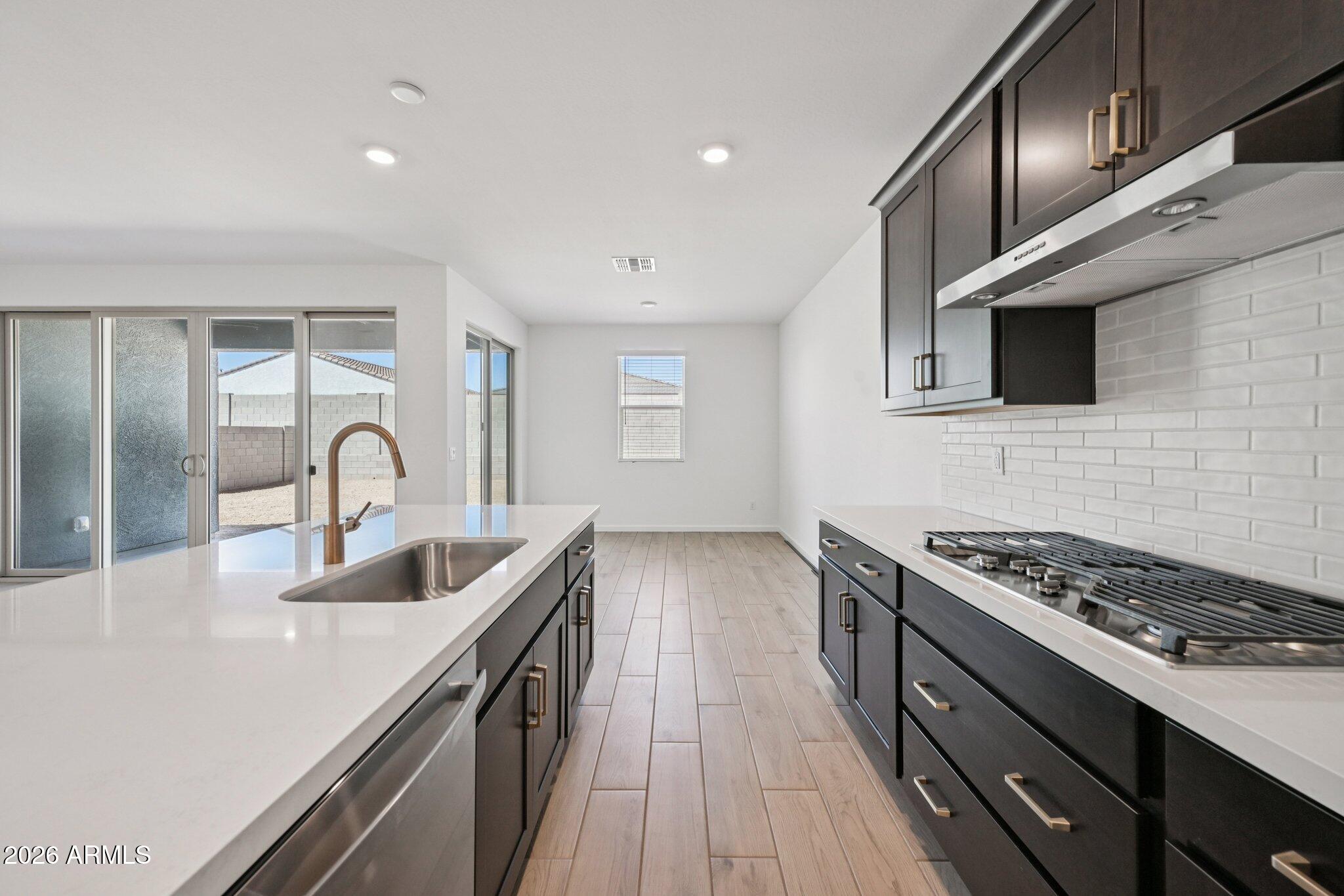 16206 West Red Bird Road Surprise, AZ 85387 - Photo 10 of 35 a kitchen with granite countertop a stove and a sink