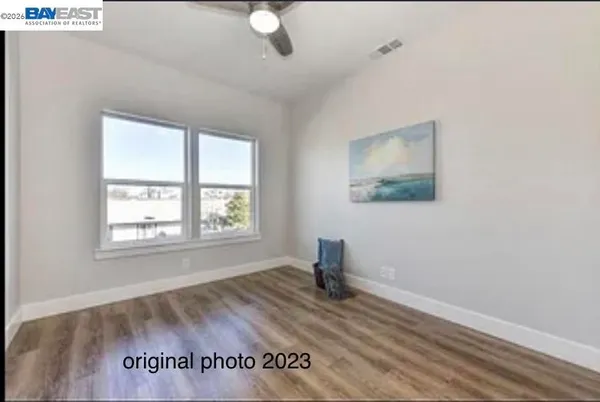a view of empty room with window and wooden floor