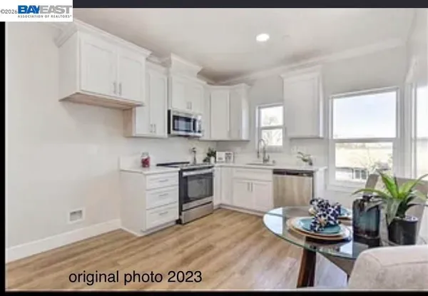 a kitchen with white cabinets and stove