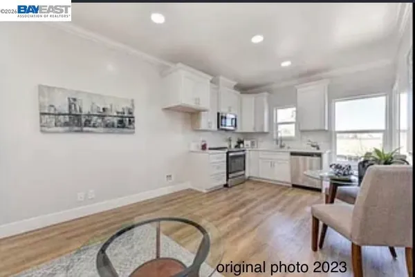 a kitchen with a stove a sink a window and chairs