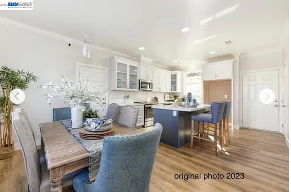 a dining room with furniture a potted plant and kitchen view