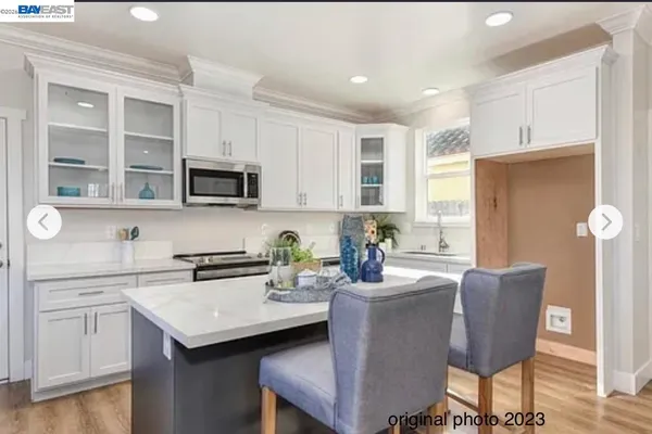 a kitchen with a sink a stove cabinets and chairs