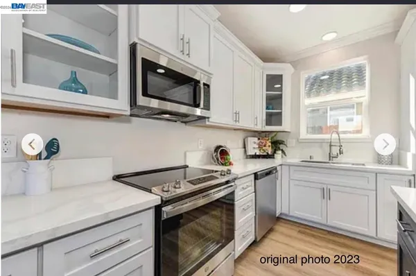a kitchen with stainless steel appliances granite countertop a sink a stove a microwave and wooden cabinets