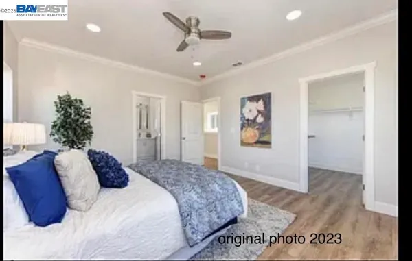 a bedroom with a large bed and a chandelier