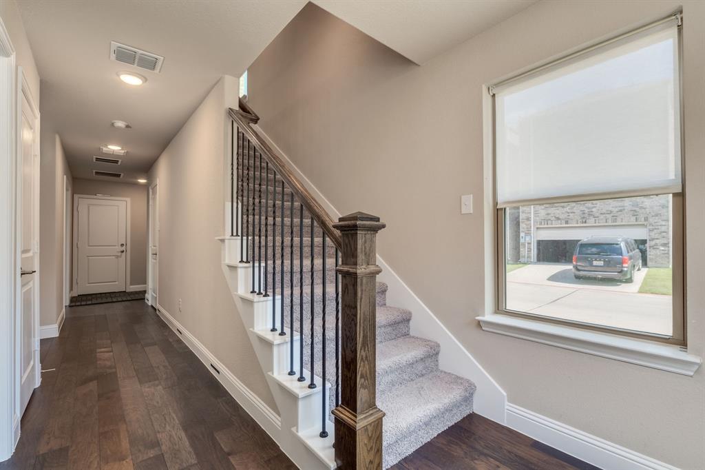 801 Cassandra Court Euless, TX 76040 - Photo 11 of 36 a view of a hallway with wooden floor and staircase