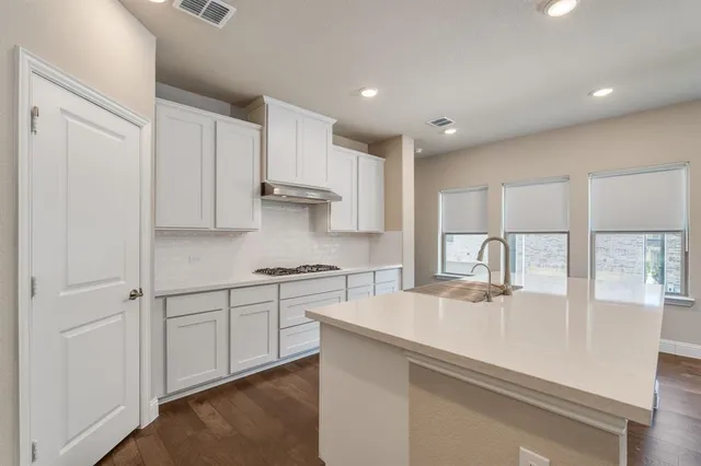 a kitchen with stainless steel appliances granite countertop a sink a stove and a refrigerator