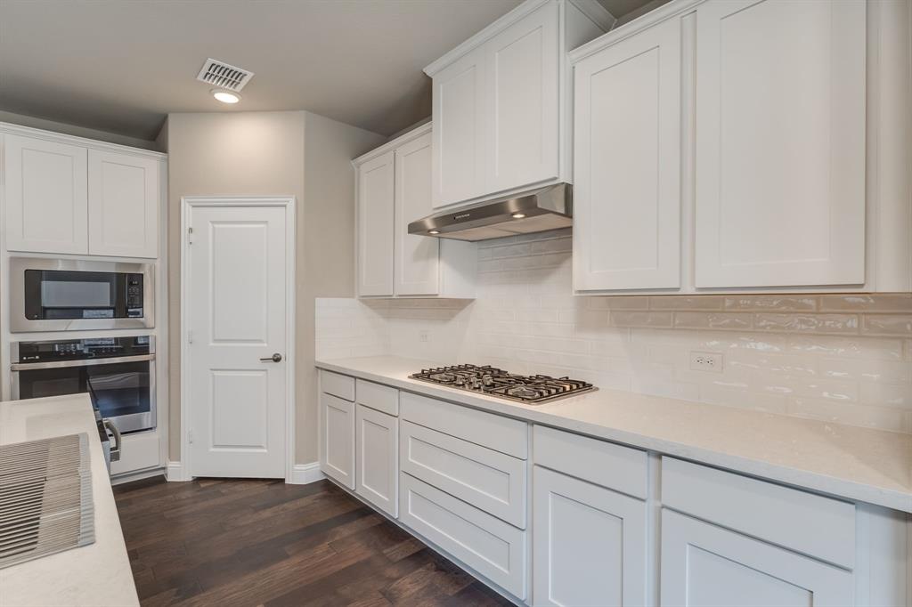 801 Cassandra Court Euless, TX 76040 - Photo 22 of 36 a kitchen with white cabinets and appliances