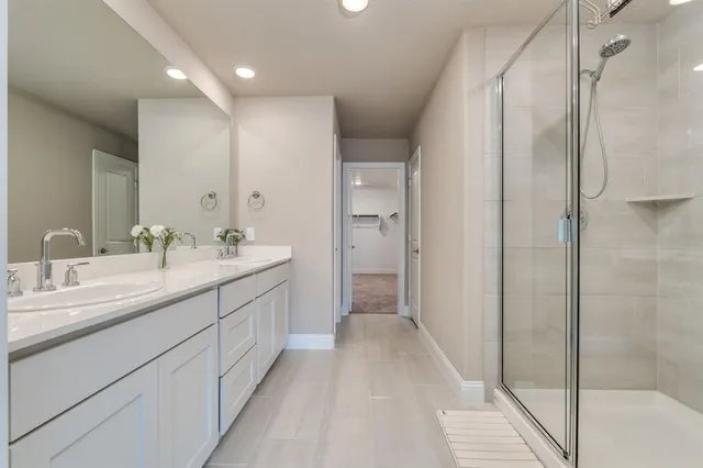 a bathroom with a double vanity sink a mirror and a shower