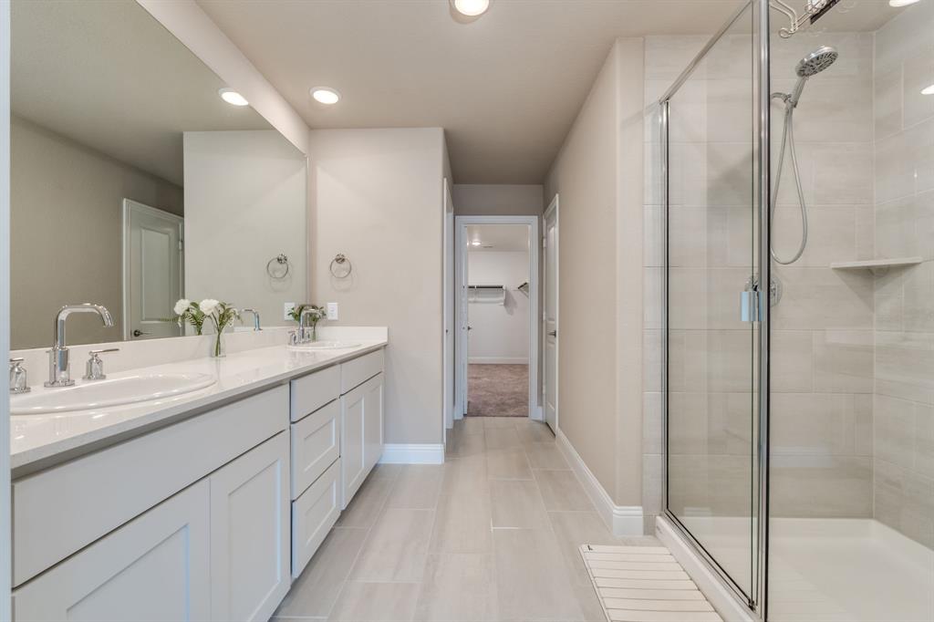 801 Cassandra Court Euless, TX 76040 - Photo 29 of 36 a bathroom with a double vanity sink a mirror and a shower