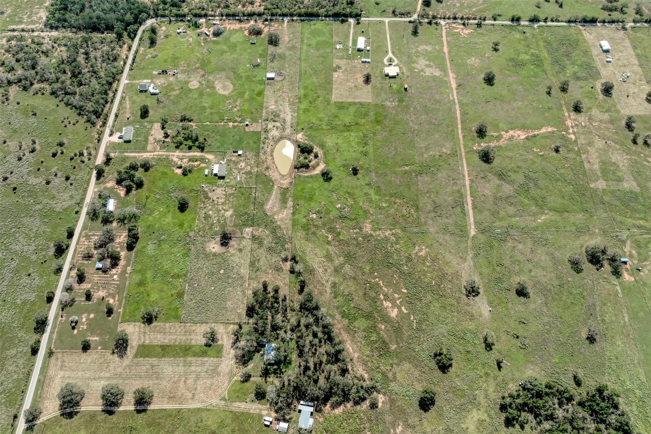 5309 Tenney Creek Road Luling, TX 78648 - Photo 18 of 23 Vast green acres with scattered homes and a tranquil pond, offering serene country living.