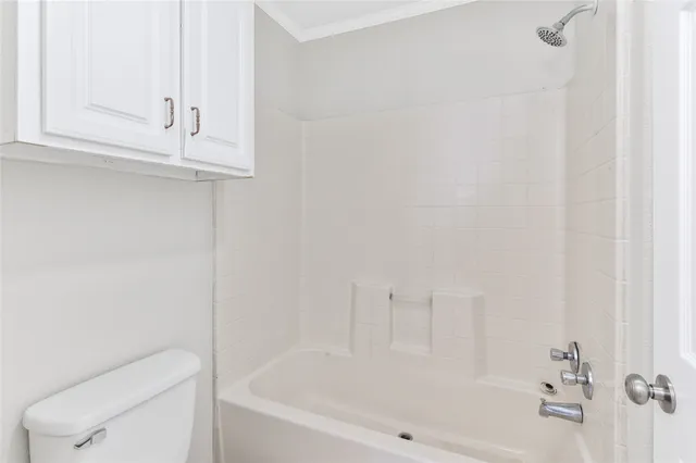 a white bath tub sitting next to a white cabinet