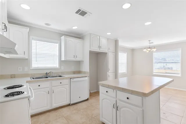 a kitchen with white cabinets and sink