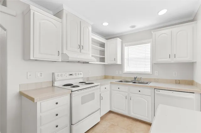a kitchen with cabinets appliances a sink and a window