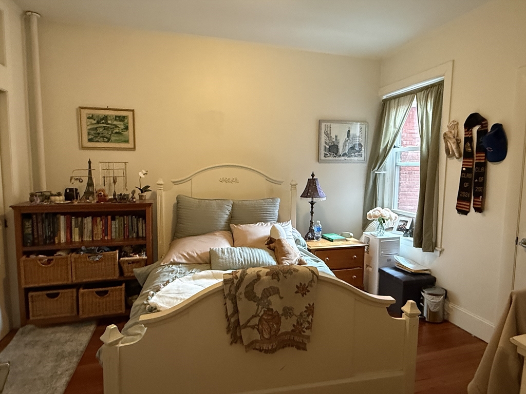 1871 Beacon Street, Unit 4 Brookline, MA 02445 - Photo 3 of 14 a bedroom with a bed and wooden floor