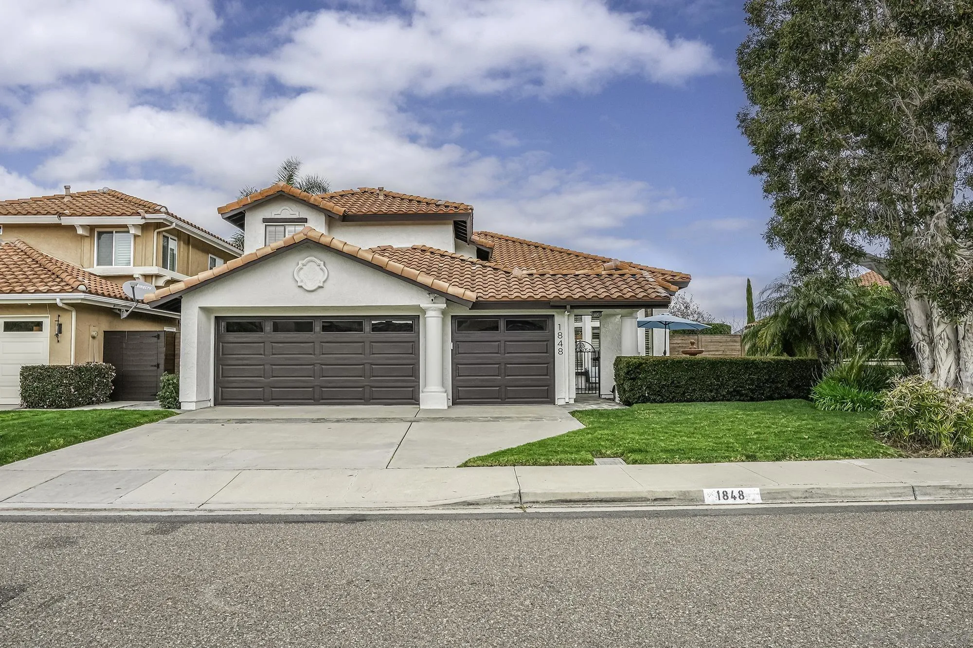 a front view of a house with a garden and trees
