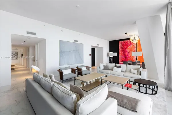 a living room with stainless steel appliances kitchen island granite countertop furniture and a large window