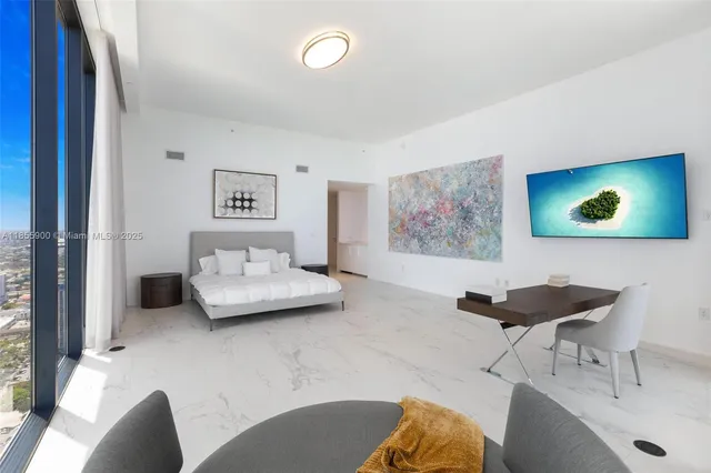 a bedroom with a large bed and a large window