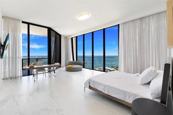 a bedroom with furniture and large windows