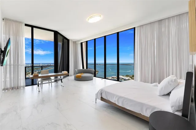 a bedroom with furniture and large windows