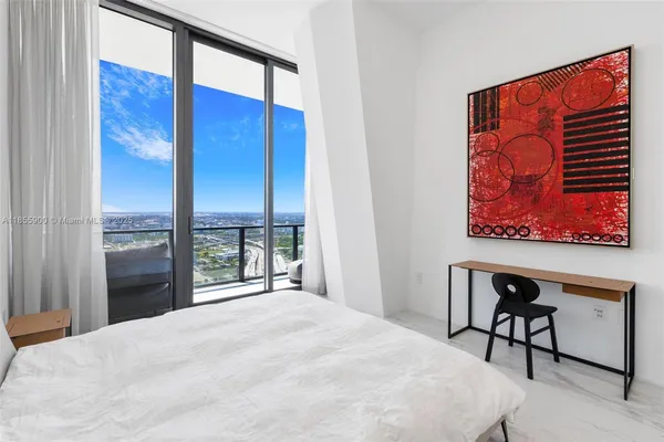 a bedroom with a bed and a dresser next to a window