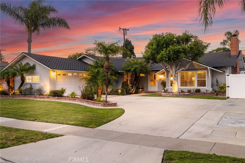 a view of a house with a yard and palm trees