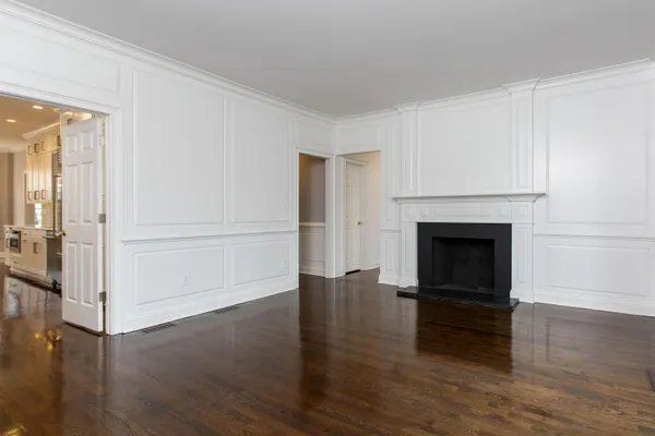 a view of a livingroom with wooden floor and a fireplace