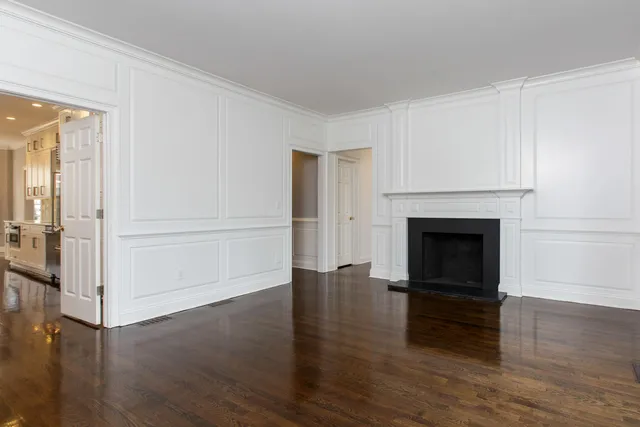 a view of a livingroom with wooden floor and a fireplace