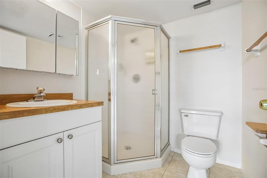 26485 Rampart Boulevard, Unit A27 Punta Gorda, FL 33983 - Photo 14 of 27 a bathroom with a granite countertop sink a toilet and shower