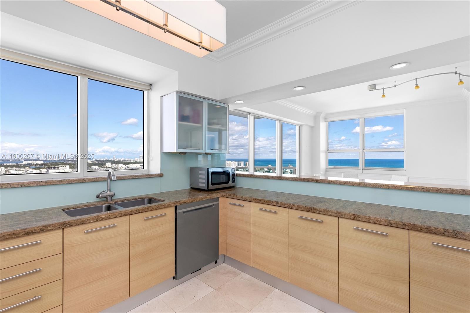 650 West Avenue, Unit PH12 Miami Beach, FL 33139 - Photo 11 of 37 a kitchen with sink window and cabinets